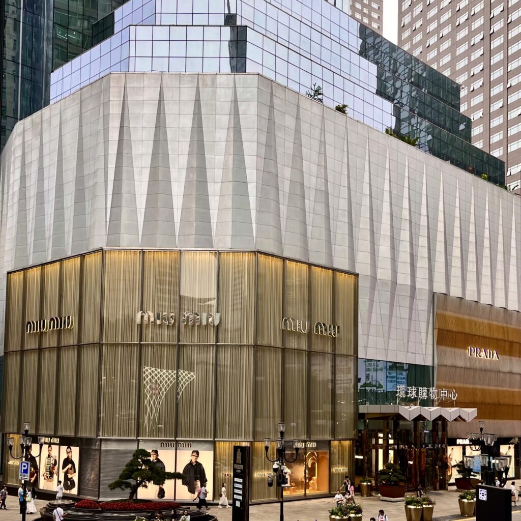 Shoppers walking past luxury brand stores in Jiefangbei Pedestrian Street