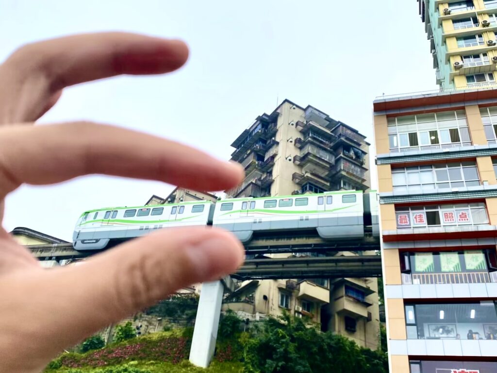 People are getting creative at the Liziba light rail that runs through a building — even pretending to pinch the train with their fingers.